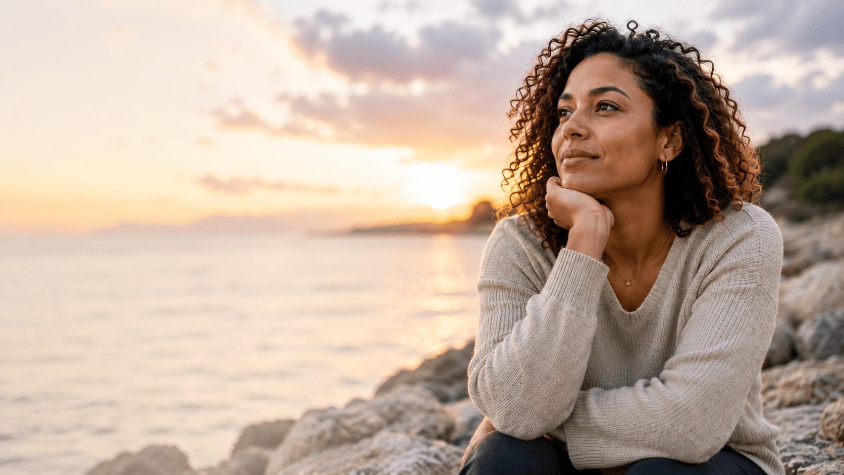 A woman sitting and gazing at the sunset